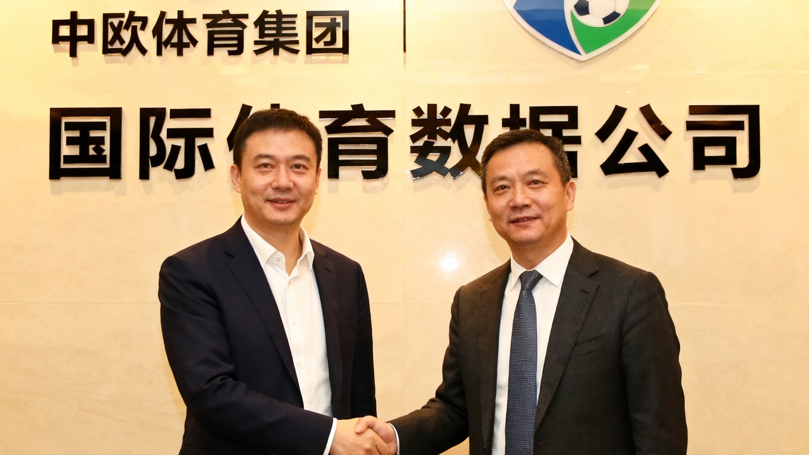 中欧体育集团与某国际体育数据公司签约仪式的照片，双方代表握手，背景是合作标识墙。